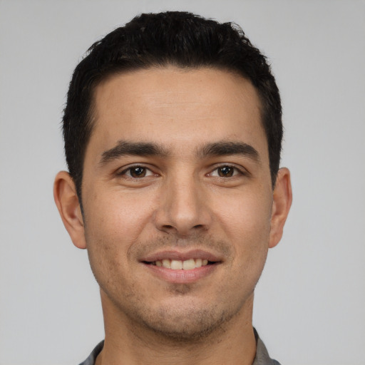 Joyful white young-adult male with short  black hair and brown eyes