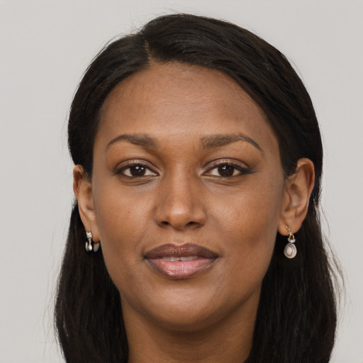 Joyful black adult female with long  brown hair and brown eyes