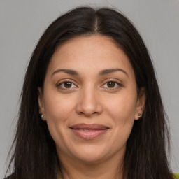 Joyful latino young-adult female with long  brown hair and brown eyes