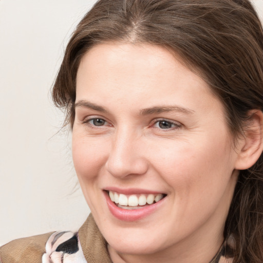 Joyful white young-adult female with medium  brown hair and grey eyes