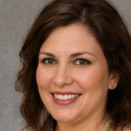 Joyful white adult female with medium  brown hair and brown eyes