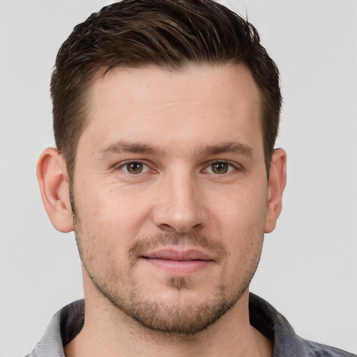 Joyful white young-adult male with short  brown hair and grey eyes