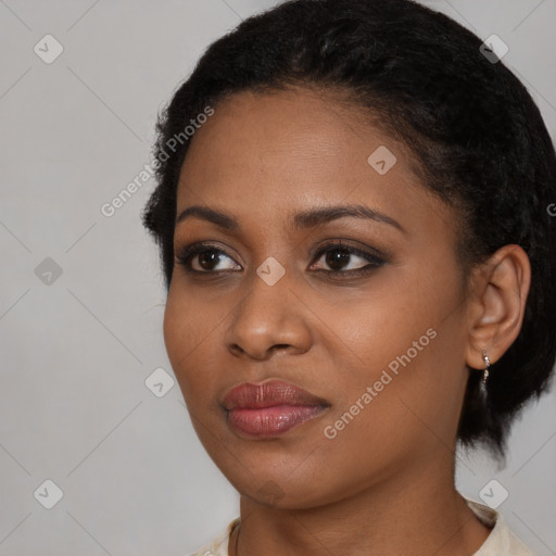 Joyful black young-adult female with short  black hair and brown eyes