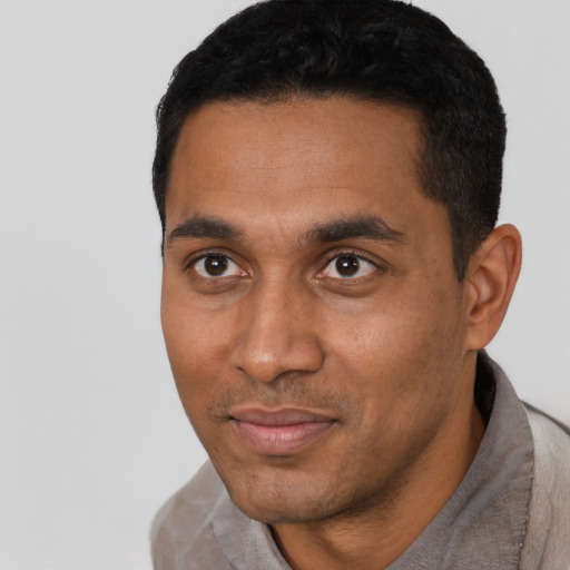Joyful black young-adult male with short  black hair and brown eyes