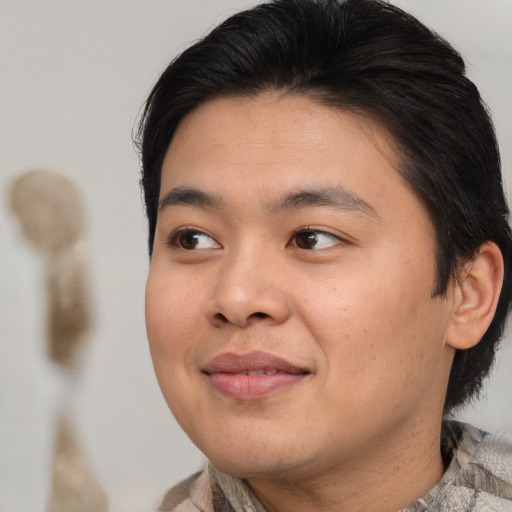 Joyful asian young-adult male with medium  brown hair and brown eyes