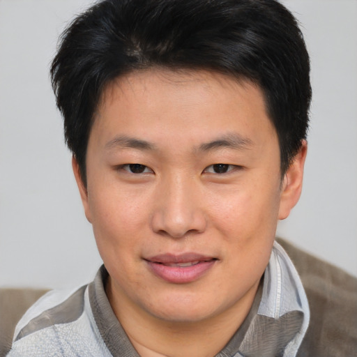 Joyful asian young-adult male with short  brown hair and brown eyes