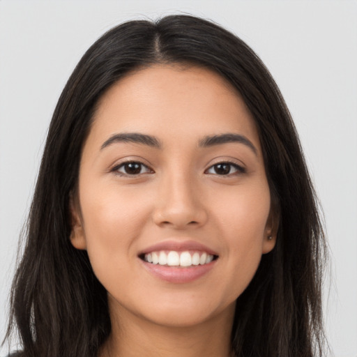 Joyful latino young-adult female with long  brown hair and brown eyes