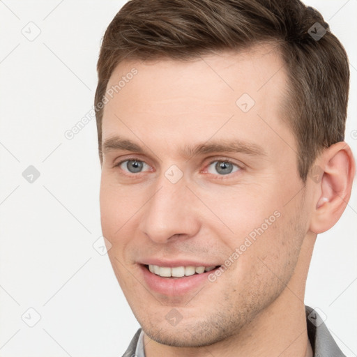 Joyful white young-adult male with short  brown hair and grey eyes