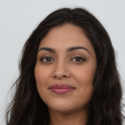 Joyful latino young-adult female with long  brown hair and brown eyes