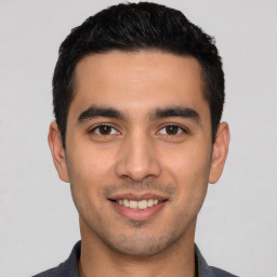 Joyful white young-adult male with short  black hair and brown eyes