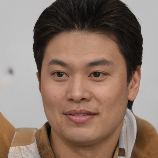 Joyful asian young-adult male with short  brown hair and brown eyes