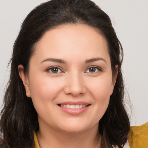 Joyful white young-adult female with long  brown hair and brown eyes