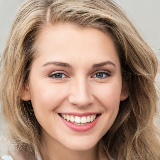 Joyful white young-adult female with long  brown hair and blue eyes