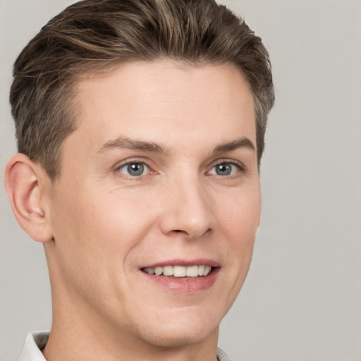 Joyful white young-adult male with short  brown hair and grey eyes