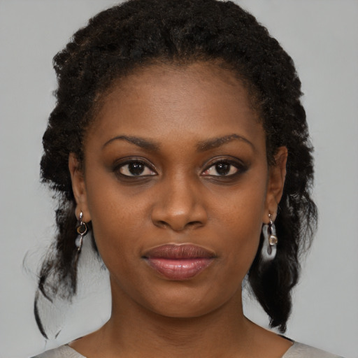 Joyful black young-adult female with medium  brown hair and brown eyes