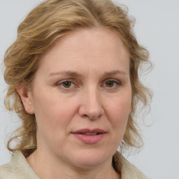 Joyful white adult female with medium  brown hair and blue eyes