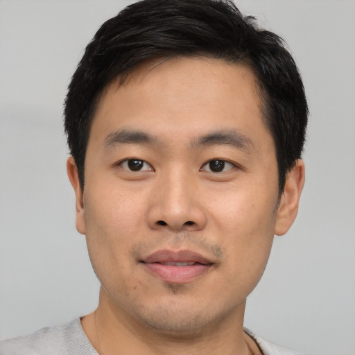 Joyful asian young-adult male with short  black hair and brown eyes