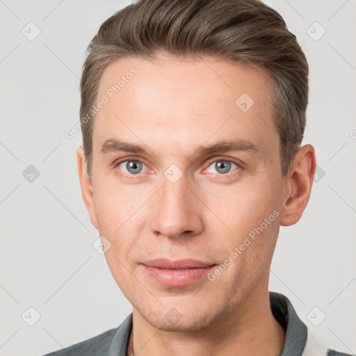 Joyful white young-adult male with short  brown hair and grey eyes