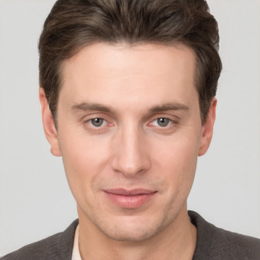 Joyful white young-adult male with short  brown hair and grey eyes