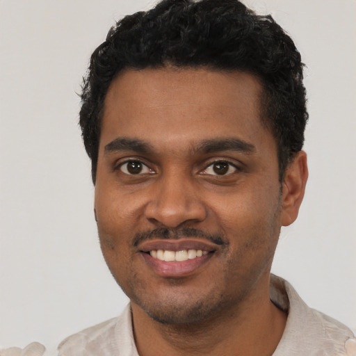 Joyful black young-adult male with short  black hair and brown eyes