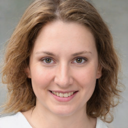 Joyful white young-adult female with medium  brown hair and green eyes