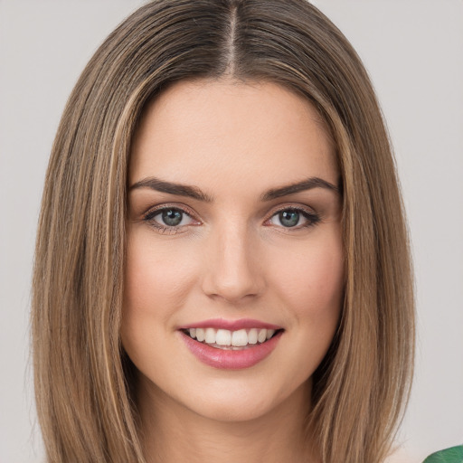 Joyful white young-adult female with long  brown hair and green eyes