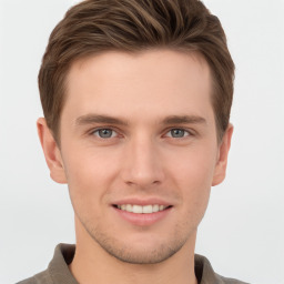 Joyful white young-adult male with short  brown hair and grey eyes