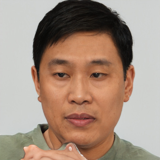 Joyful asian adult male with short  black hair and brown eyes