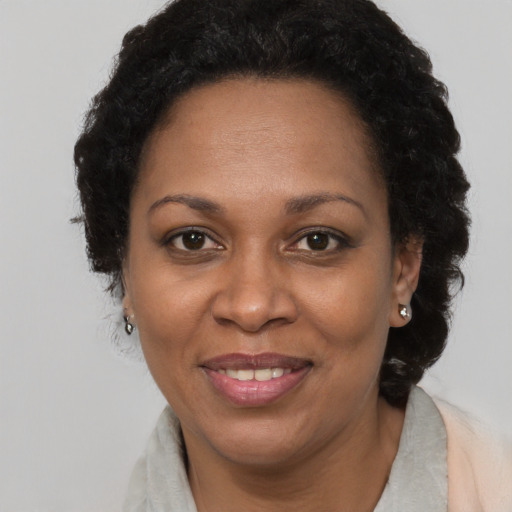 Joyful black adult female with short  brown hair and brown eyes