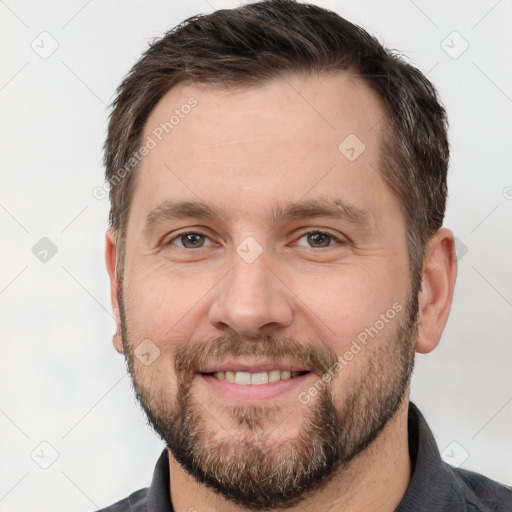 Joyful white adult male with short  brown hair and brown eyes