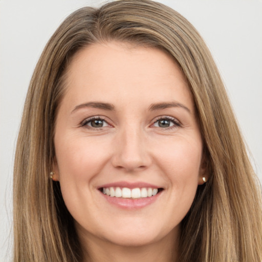 Joyful white young-adult female with long  brown hair and brown eyes