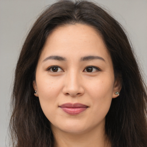Joyful asian young-adult female with long  brown hair and brown eyes