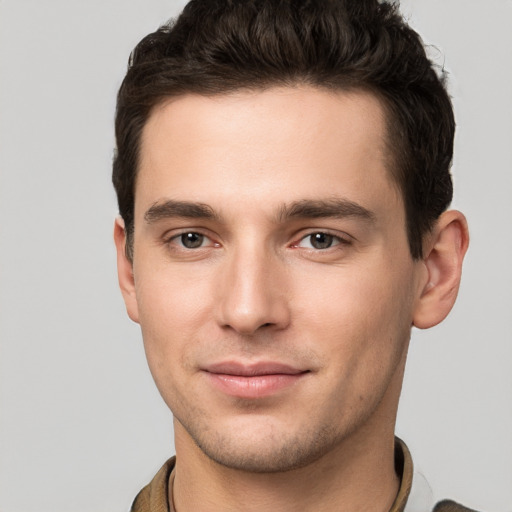 Joyful white young-adult male with short  brown hair and grey eyes