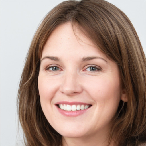 Joyful white young-adult female with long  brown hair and grey eyes