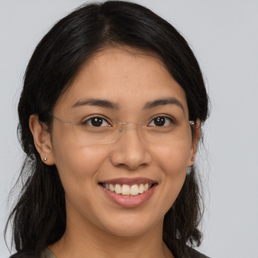 Joyful latino young-adult female with long  brown hair and brown eyes