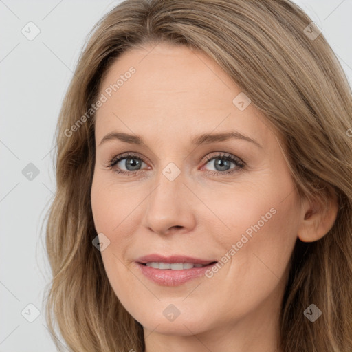 Joyful white young-adult female with long  brown hair and blue eyes