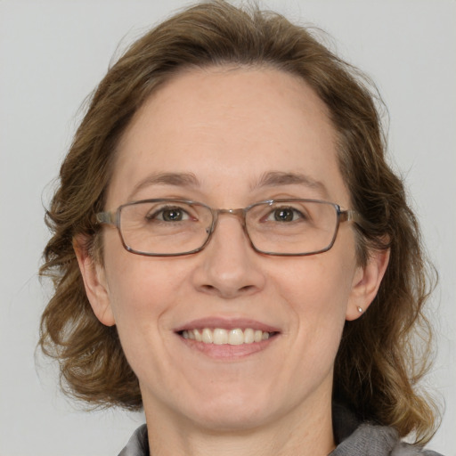 Joyful white adult female with medium  brown hair and grey eyes