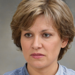 Joyful white adult female with medium  brown hair and blue eyes