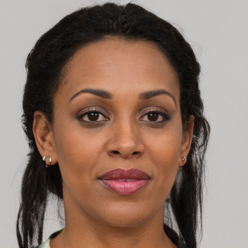 Joyful black adult female with long  brown hair and brown eyes