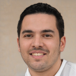 Joyful white young-adult male with short  black hair and brown eyes