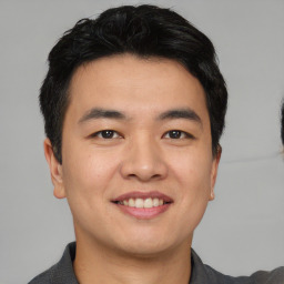 Joyful asian young-adult male with short  black hair and brown eyes