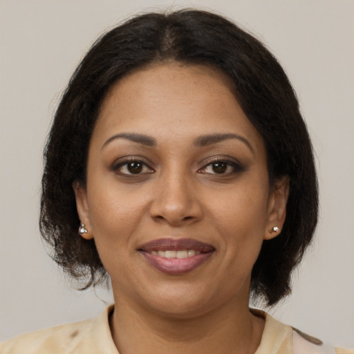 Joyful black adult female with medium  brown hair and brown eyes