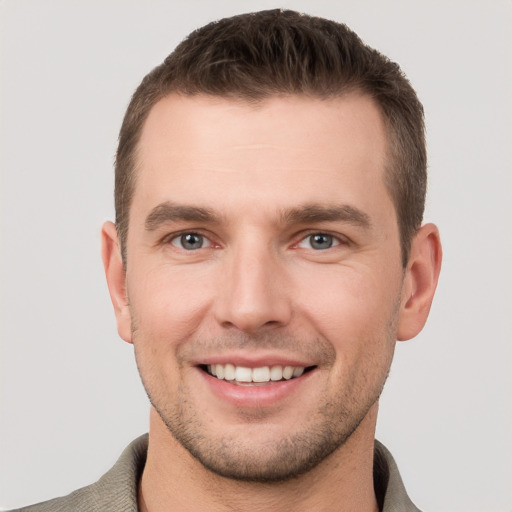 Joyful white young-adult male with short  brown hair and grey eyes