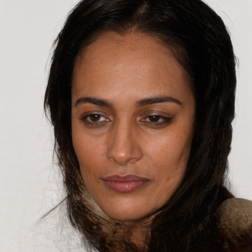 Joyful latino adult female with long  brown hair and brown eyes