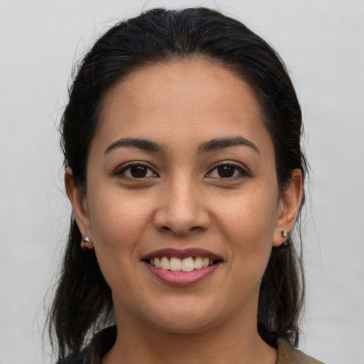 Joyful latino young-adult female with long  brown hair and brown eyes