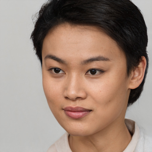 Joyful asian young-adult female with short  brown hair and brown eyes