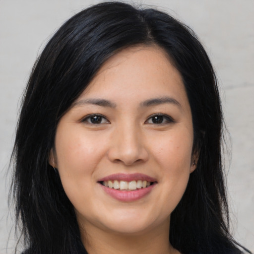 Joyful asian young-adult female with long  black hair and brown eyes
