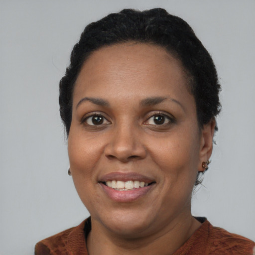 Joyful black adult female with short  black hair and brown eyes