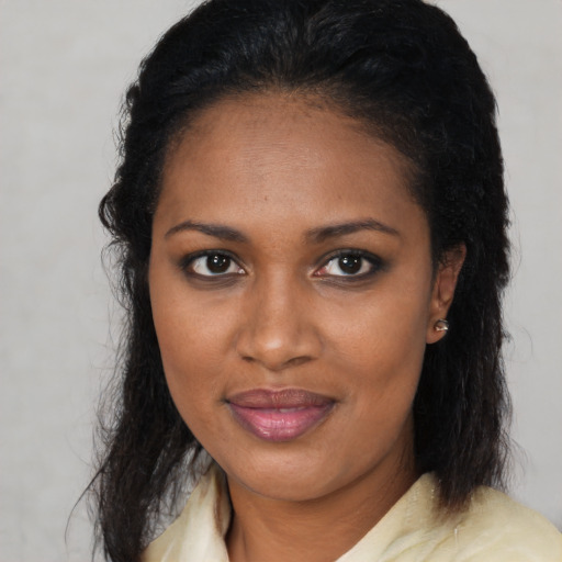 Joyful black young-adult female with long  brown hair and brown eyes