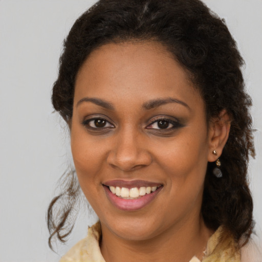 Joyful black young-adult female with medium  brown hair and brown eyes